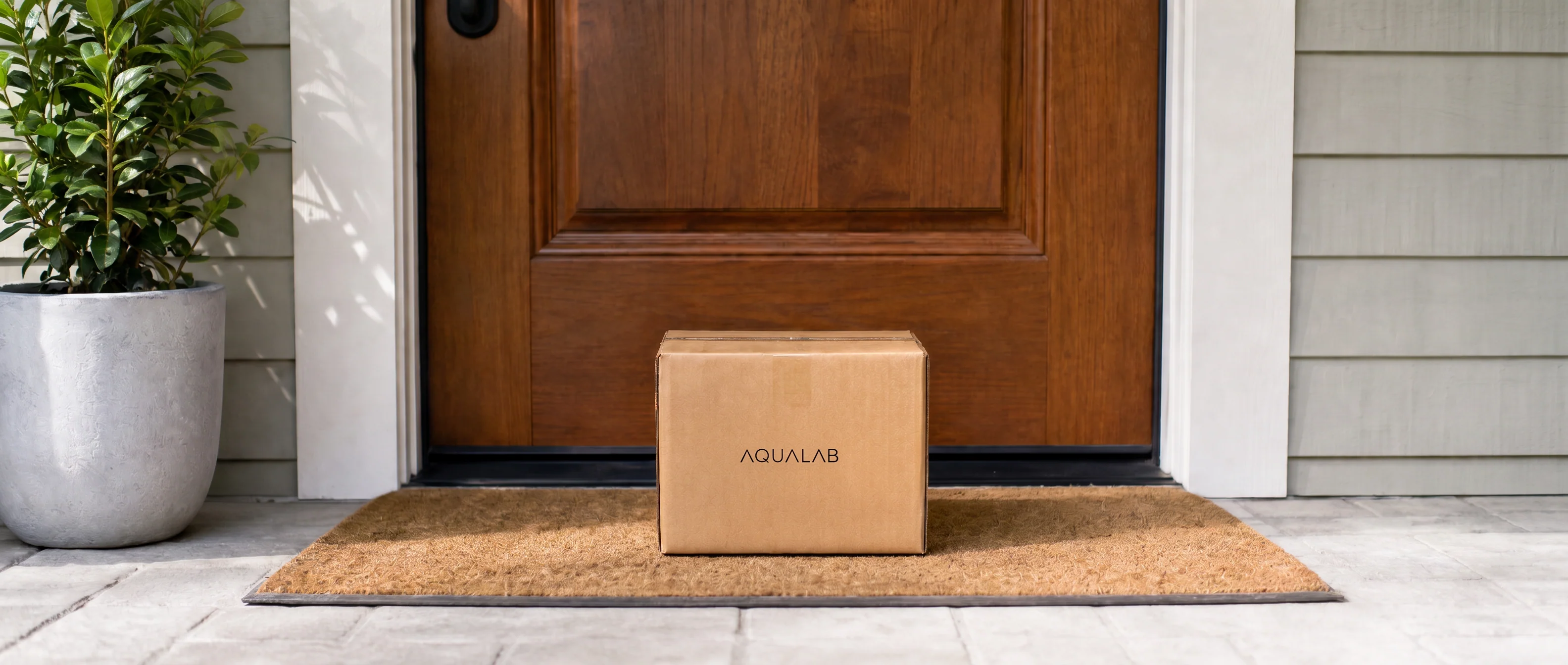 An AquaLabs parcel waiting on a doormat at a front door